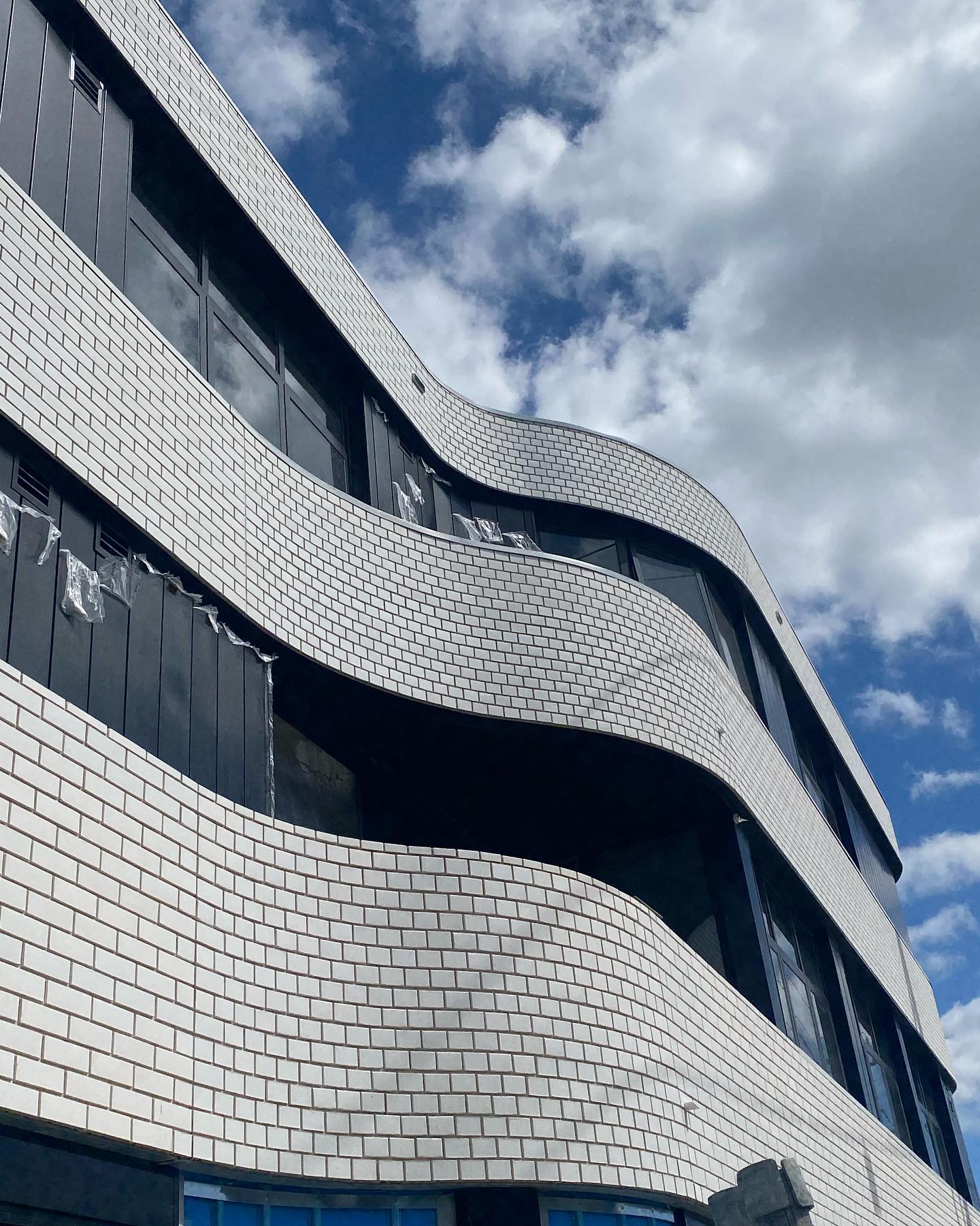 Curved white glazed brick facade on a commercial building.