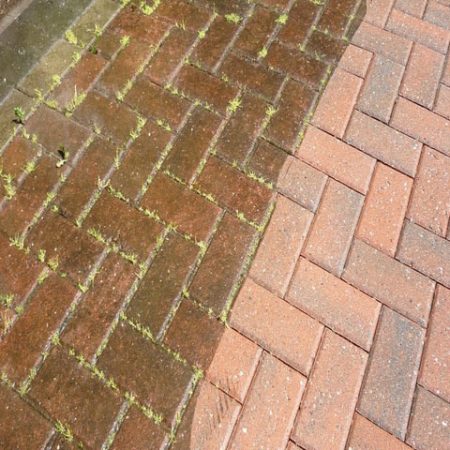 Red herringbone clay pavers, half still stained and half cleaned.