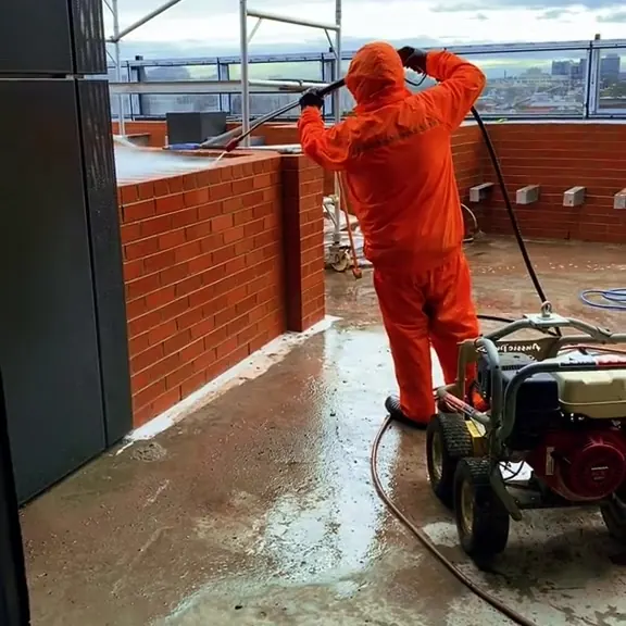 Spotless crew member washing a commercial rooftop terrace