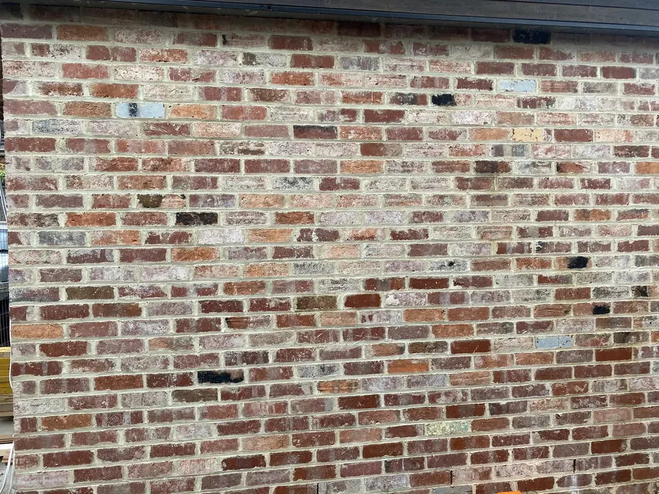 Before: red face brick covered in grey mortar smear